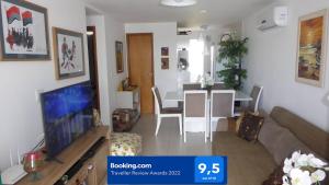 a living room with a couch and a table with a tv at Praia de Guarajuba-Porto Smeralda in Guarajuba