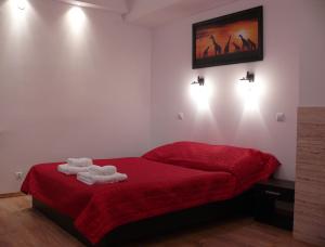 Un dormitorio con una cama roja con toallas. en Apartamenty Pokoje DreamZone, en Lublin