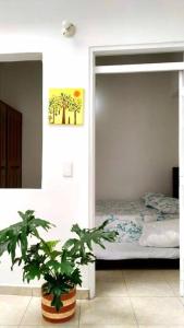 ein Schlafzimmer mit einem Bett und einer Topfpflanze in der Unterkunft Apartamento amoblado en La Tebaida, Quindio in La Tebaida