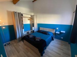 a blue bedroom with a bed and a mirror at La Villa de la Plage in Argelès-sur-Mer