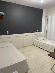 Zimmer mit 2 Betten und einer schwarzen Wand in der Unterkunft BRAVO CITY HOTEL CAMPO VERDE in Campo Verde