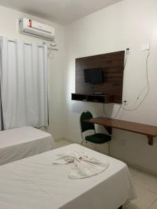 a hotel room with two beds and a desk with a computer at BRAVO CITY HOTEL CAMPO VERDE in Campo Verde