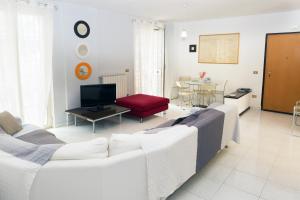 a living room with a white couch and a tv at Merola Sisters Holiday Home in Caserta