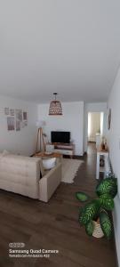 a living room with a white couch and a tv at Espacio arredondo castelar in Castelar