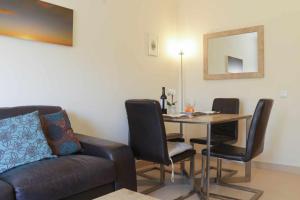 ein Wohnzimmer mit Tisch und Couch in der Unterkunft Apartamento Maresia T2 Penthouse by Your Home Algarve in Cabanas de Tavira