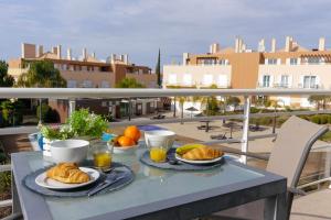 un tavolo con due piatti di cibo su un balcone di Apartamento AzulMar Cabanas Gardens by Your Home Algarve a Armação da Abóbora