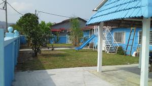 uma casa azul com um parque infantil com um escorrega em Apple Boutique Homestay em Kuantan