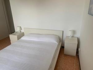 - une chambre avec un lit blanc et 2 tables de chevet dans l'établissement Vista mozzafiato sul mare!, à Sperlonga