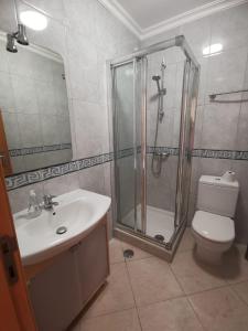 a bathroom with a shower and a toilet and a sink at Alvor Vila da Praia in Alvor