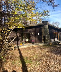 a black house with a yard in front of it at Forest Lodge in Petit Mesnil