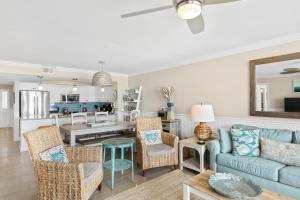 a living room with a blue couch and a table at 115 Charleston Oceanfront Villas Beach Daze in Folly Beach