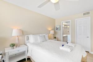 a white bedroom with a white bed with two pillows at 115 Charleston Oceanfront Villas Beach Daze in Folly Beach +33 photos