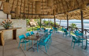 a patio area with chairs, tables and umbrellas at Quinta Real Acapulco in Acapulco