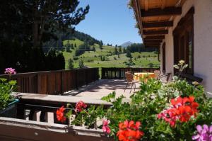 einen Balkon mit einem Tisch, Stühlen und Blumen in der Unterkunft Haus Tiroler Heimat in Nauders