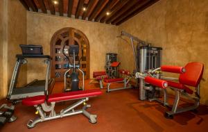 a gym with red chairs and equipment in a room at Quinta Real Oaxaca in Oaxaca City