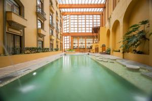 a swimming pool in a building with a large window at Quinta Real Monterrey in Monterrey