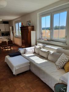 a living room with a white couch and windows at Ferienhaus Kerschbaum in Wiener Neustadt in Wiener Neustadt