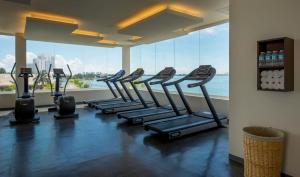 a row of treadmills in a gym with a large window at Real Inn Cancún in Cancún