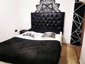 a black bed with a black headboard in a bedroom at Hermoso apartamento en el centro histórico de San Gil I 2 in San Gil