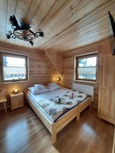 a bedroom with a bed in a wooden cabin at Domek Przekolec in Szaflary