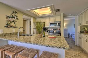 a kitchen with a sink and a counter with bar stools at Siesta Key Condo Resort Amenities, Walk to Beach! in Siesta Key