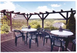 zwei Tische und Stühle auf einer Terrasse mit einer Pergola in der Unterkunft Landgasthaus Blick ins Tal in Wißmannsdorf