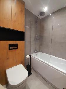 a bathroom with a toilet and a tub and a sink at Apartament Nad wierzbami in Piechowice