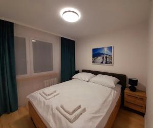 een slaapkamer met een groot bed met witte lakens bij Apartament Nad wierzbami in Piechowice