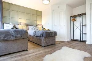 a bedroom with two beds and a couch at Luxury 5 Bedroom 3 Bathroom House - Smart TVs with Sky and Netflix, Super Fast WiFi, Free Parking by Yoko Property in Milton Keynes