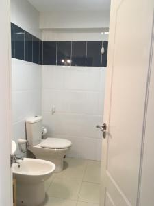 een witte badkamer met een toilet en een wastafel bij Los Roques in La Laguna