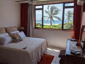 a bedroom with a bed with a view of the ocean at Capri24 - Modern apartment overlooking the sea in Amanzimtoti