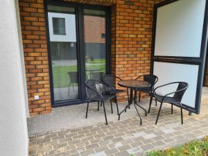 a patio with four chairs and a table in front of a building at Apartament Mickiewicza in Puck