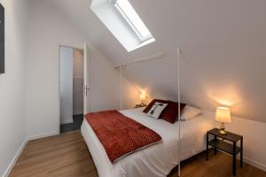 a bedroom with a bed and a skylight at Les Clés de La porte Saint-Nicolas - Parking - Centre in Beaune