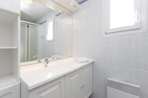 Heudicourt-sous-les-CôtesにあるHébergements du Lac de Madineの洗面台と鏡のある白いバスルーム +36枚の写真