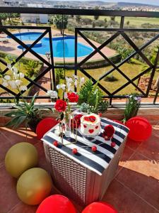 a picnic table on a balcony with a view of a pool at FamilyConfort Saidia in Saïdia