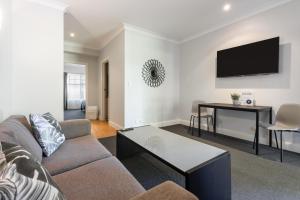 a living room with a couch and a tv on a wall at St Francis Winery in Old Reynella