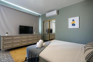 1 dormitorio con 1 cama y TV de pantalla plana en La Buena Vida Inn en San Juan