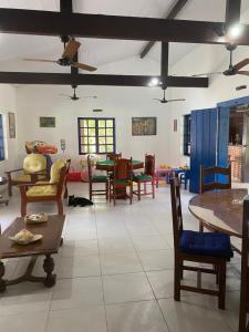 - un salon avec des chaises et des tables ainsi qu'une salle à manger dans l'établissement Pousada Catavento, à Saquarema