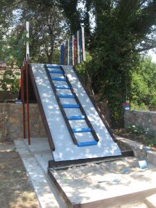 a metal slide in the middle of a park at Apartments Draga in Budva