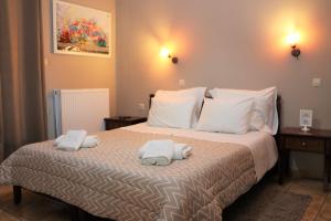 a bedroom with a bed with towels on it at Tzovolos Apartments in Kalavrita