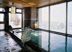 钏路Dormy Inn PREMIUM Kushiro的带有大窗户的建筑内的游泳池