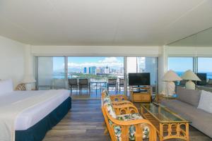 a bedroom with a bed and a couch and a tv at Ilikai Tower 2141 Yacht Harbor View 1BR in Honolulu