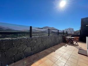 pared de piedra con mesa y sillas en el patio en Eslanzarote Casa Carait, Super wifi, Sat tv, en La Vegueta