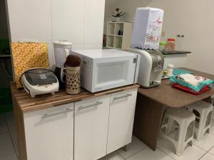 um balcão de cozinha com um micro-ondas e uma impressora em Condomínio Portal de Maragogi- Flats duplex super aconchegantes e confortáveis em Maragogi