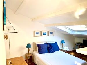 a bedroom with a large bed with blue pillows at Le 1835, Studio Bleu-Coton in Moustiers-Sainte-Marie