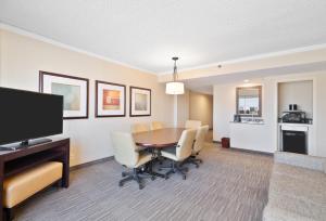 a dining room with a table and chairs and a television at Harmony Suites Secaucus Meadowlands in Secaucus