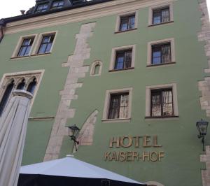 レーゲンスブルクにあるホテル カイザーホフ アム ドムのホテルのカスターホッグという言葉を持つ緑の建物