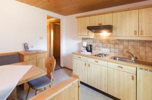 kuchnia z drewnianymi szafkami i zlewem w obiekcie Appartement Jägerhof w Solden