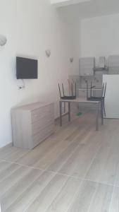 a room with a desk and chairs and a tv at SanMarco Holiday Home in Ascea