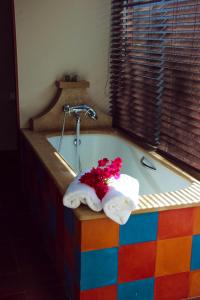 a bathroom with a colorful tub with flowers in it at La Perle du Lagon in Le François
